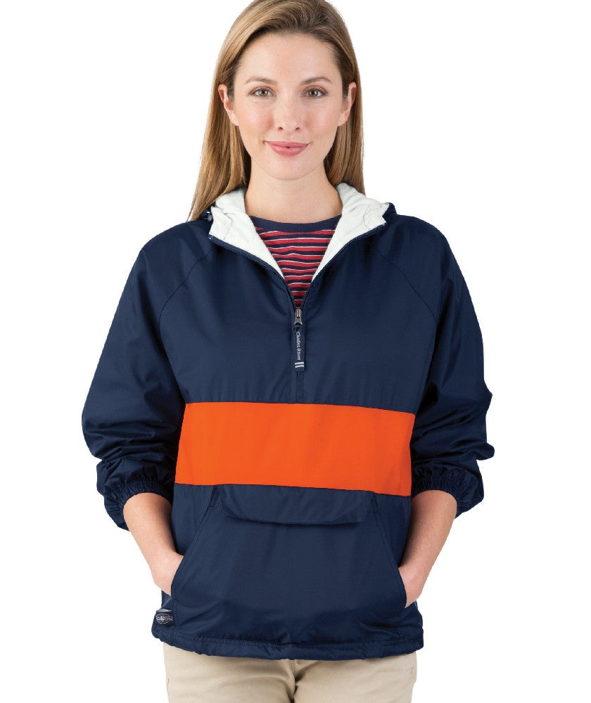 Woman wearing a navy and orange pullover with a white background