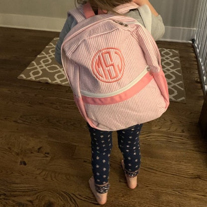day care or pre school backpack made of pink seersucker striped material with a pink monogram