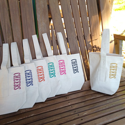 natural canvas 2 bottle wine totes with the word CHEERS embroidered in different thread colors