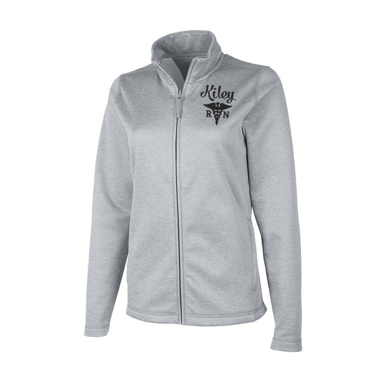 RN Nurse Jacket- Scrubs Jacket - A light gray heather zip-up jacket with a stand collar, featuring a black embroidered logo on the left chest that reads 'Kiley RN' with a caduceus medical graphic, shown against a plain white background.
