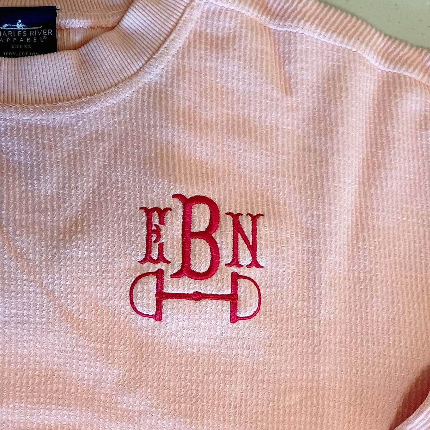 pink corded sweatshirt with horse bit monogram
