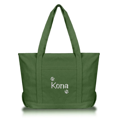 Green tote bag with dog name and paws embroidered on it against a white background