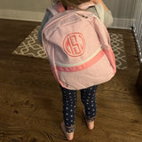 child modeling pink seersucker stripe backpack with monogram