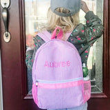 child wearing pink seersucker stripe backpack with name embroidered on the backpack
